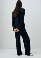 Blazer de corte recto y diseño de raya diplomática, con cuello de solapa con muesca, cierre frontal de doble botonadura y mangas largas con puños abotonados. Cuenta con forro interior y dos bolsillos de solapa en la parte frontal.