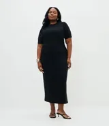 Vestido midi de Ashua, confeccionado en tejido de punto con cuello redondo y mangas cortas. Presenta un diseño ajustado con detalle de fruncido lateral que realza la silueta.