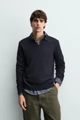 Sweater polo de punto de mezcla de algodón en color negro, con cuello solapa, abertura frontal y mangas largas con acabado en rib.