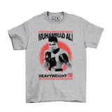 Remera gris jaspeado con estampa frontal de Muhammad Ali en blanco y negro sobre un círculo rojo, con tipografía alusiva al boxeo.