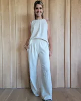 Pantalón de algodón color arena, de corte recto y holgado, con cintura elástica y detalle de costuras horizontales decorativas en la parte inferior de las piernas.