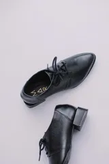 Zapato acordonado de cuero color beige con taco de madera de 3 cm.