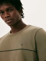 Pijama de hombre compuesto por una remera de manga corta color verde oliva con una línea horizontal negra y un pequeño logo en forma de 'x' en el pecho, y un short negro liso.