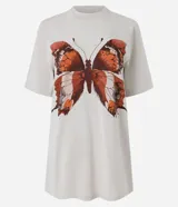 Remera oversized de algodón color gris claro, con cuello redondo y mangas cortas. Presenta una estampa frontal de mariposa marmolada en tonos tierra con pequeños detalles de strass.