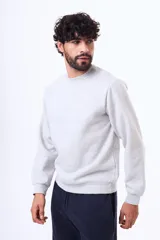 Buzo de felpa color negro, con cuello redondo, mangas largas y puños elásticos. Diseño básico y minimalista.