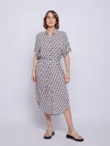 Vestido camisero midi azul con estampado floral blanco, corte recto, cuello camisero, mangas cortas, bolsillos laterales y lazo ajustable en la cintura.