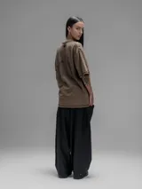 Remera de manga corta con diseño oversize, confeccionada en algodón con proceso batik artesanal en tono óxido. Presenta recortes superpuestos en el frente y costuras expuestas en mangas y cuerpo.