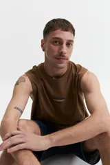 Musculosa de algodón color marrón, con corte oversize, escote redondo y un pequeño estampado en relieve en el pecho.