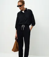 Pantalón tipo jogger de corte holgado con cintura elástica y cordón bicolor ajustable. Presenta puños elásticos en los tobillos y bolsillos laterales.