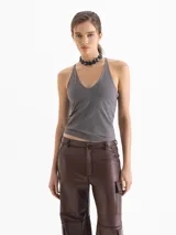 Top gris de punto, ajustado al cuerpo, con escote en V pronunciado y breteles finos que se unen en la espalda.