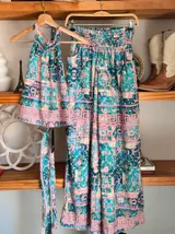 Conjunto de dos piezas color fucsia con estampado oriental en tonos rosa y blanco, compuesto por un top halter con lazo en la cintura y un pantalón palazzo de cintura alta con elástico.