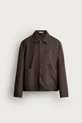 Sobrecamisa de corte regular fit en color marrón oscuro, confeccionada en tejido de algodón. Presenta cuello solapa, cierre frontal con botones, manga larga y tres bolsillos plastrón en el frente.