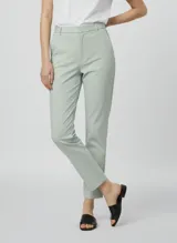 Pantalón de vestir de corte recto y tiro alto, color verde menta pálido. Presenta pliegues marcados en el frente y bolsillos laterales.