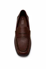 Mocasín de símil cuero negro con silueta clásica, costuras marcadas y tira sobre el empeine.