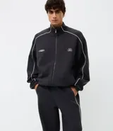 Pantalón deportivo de corte recto y estilo holgado, color negro con una línea vertical blanca en los laterales. Cuenta con cintura elástica con cordón de ajuste y bolsillos laterales.