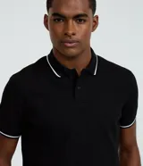 Remera polo blanca de viscosa texturizada con rayas, cuello y puños de mangas cortas en ribana con detalles contrastantes en negro.