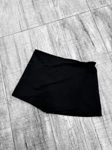 Short pollera negro de crepe, con cintura elastizada.