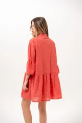 Vestido corto coral de broderie, con cuello camisero, cierre frontal de botones, mangas tres cuartos con volados y diseño escalonado en la falda.