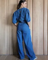 Pantalón de denim azul, de corte recto y tiro alto, con cintura elástica y cordón ajustable. Tiene bolsillos laterales.