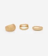 Kit de tres anillos para mujer con baño dorado claro y diferentes diseños. El conjunto incluye un anillo ancho con textura acanalada, un anillo de doble banda y un anillo liso tipo domo. Confeccionados en metal reciclado.