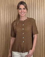 Cardigan de punto color tostado, de manga corta y cuello redondo, con cierre frontal de botones y diseño texturizado.