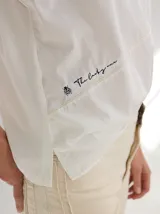 Remera de silueta relajada con cortes geométricos en el frente y costuras a la vista en tono contrastante. Presenta cuello redondo y mangas largas.