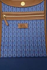 Bolso tipo tote de hombro con cuerpo estampado en tonos azules con patrón geométrico. Cuenta con detalles en tono tostado en las asas dobles, bordes y costuras en contraste. Cierre mediante botón imantado y compartimento interior.
