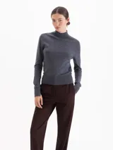 Polera de cuello alto y manga larga, confeccionada en tejido de punto fino con calce entallado al cuerpo.
