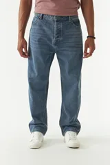 Jean de corte baggy con tiro medio, diseño amplio en piernas y cadera, con cierre y botón frontal.