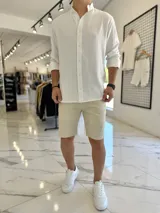 Camisa oversize de lino color blanco, con cuello mao, manga larga y cierre frontal de botones.