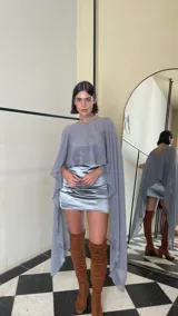 Vestido corto de dos piezas compuesto por una base strapless con frunces y acabado satinado, acompañada de una capa transparente desmontable de corte asimétrico.