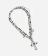 Collar masculino de metal plateado con diseño de cadenas múltiples superpuestas de eslabones variados, dije principal en forma de cruz con detalles ornamentales y pequeños dijes colgantes, con cierre ajustable mediante extensor.