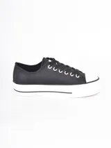 Zapatillas de plataforma estilo urbano, color negro con puntera y suela de goma blanca. Cuentan con cordones negros y ojales metálicos.