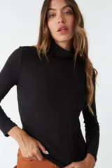 Remera de manga larga y cuello alto, confeccionada en tejido de punto acanalado color negro.