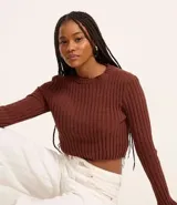 Blusa cropped color marrón, confeccionada en tejido de punto chenille texturizado, de corte ajustado, cuello redondo y mangas largas.