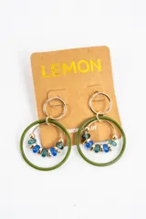 Aros colgantes formados por una argolla superior dorada, un aro grande esmaltado en color verde oliva y un aro interno dorado decorado con cuentas de cristal en tonos azules y verdes.