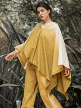 Poncho con capucha a rayas horizontales en tonos gris y blanco.