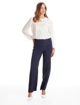 Pantalón sastrero de corte wide leg y tiro alto, con cierre frontal de gancho y cremallera. Presenta bolsillos laterales de ojal y un diseño minimalista con caída fluida.