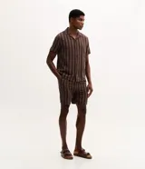 Bermuda masculina confeccionada en tejido jacquard con estampado de rayas texturizadas en color marrón. Posee cintura elástica con cordón ajustable y bolsillos laterales.