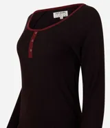 Pijama de dos piezas confeccionado en tejido rib acanalado. La blusa es de manga larga, con cuello redondo y abertura frontal parcial con botones. El pantalón es de corte recto con cintura elástica.