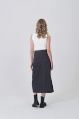 Falda larga de jean en color gris oscuro, con costuras a la vista en tono claro, bolsillos laterales y cierre frontal con botón.