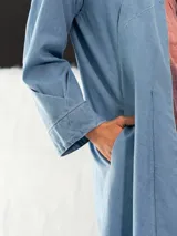 Tapado de denim celeste con cuello con pliegues y corte recto.