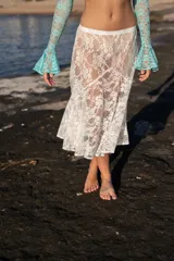 Falda midi de encaje blanco con diseño floral, corte evasé y pretina elástica.