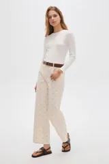 Pantalón recto de algodón color beige con estampado sutil y tiro medio.