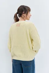 Sweater de punto en color celeste, con diseño de trenzas y textura en relieve. Presenta cuello redondo, mangas largas con puños ajustados y un corte holgado.