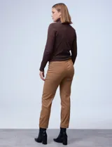 Pantalón negro de gabardina elastizada, corte slim, con pretina ancha con aplique de botones y largo de pierna pespunteado.