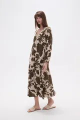 Vestido midi holgado con estampado floral en tonos verde militar y beige, cuello en V, mangas largas y falda con volados.