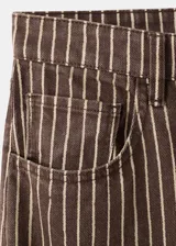 Jeans de corte recto y tiro medio, confeccionados en denim marrón con diseño de rayas verticales claras. Presenta bolsillos delanteros y traseros clásicos.