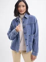Campera de jean azul con corte holgado, cuello clásico, cierre frontal con botones y bolsillos delanteros amplios.