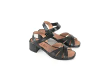 Sandalias de cuero negro con tiras cruzadas en la parte delantera y tira ajustable en el talón. Cuenta con taco bloque bajo y suela flexible.
